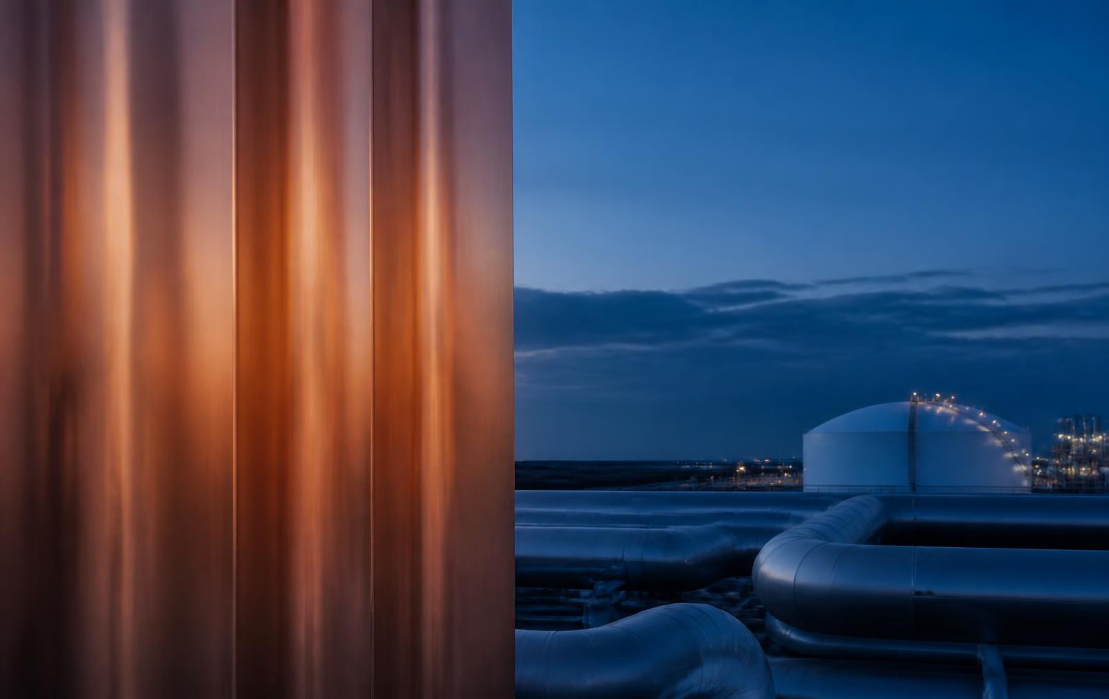 Copper surfaces and an LNG terminal at dusk
